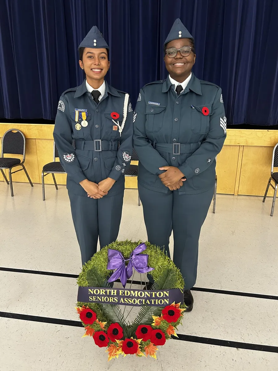 Two 12 Edmonton cadets in ceremonial dress beside a Remembrance Day wreath