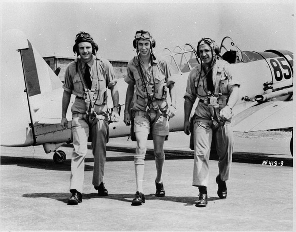 Three RCAF pilots posed with a North American Harvard II trainer at No. 31 Service Flying Training School, Kingston, 1943